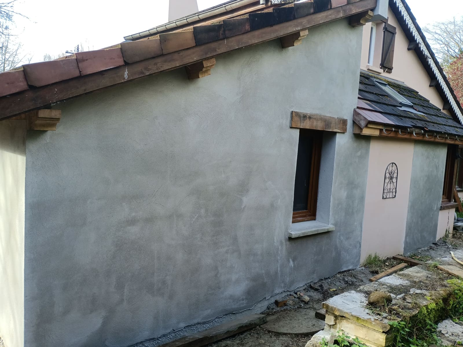 Pignon d’une maison ancienne en cours de reprise, encadrement de fenêtre en pierre conservé