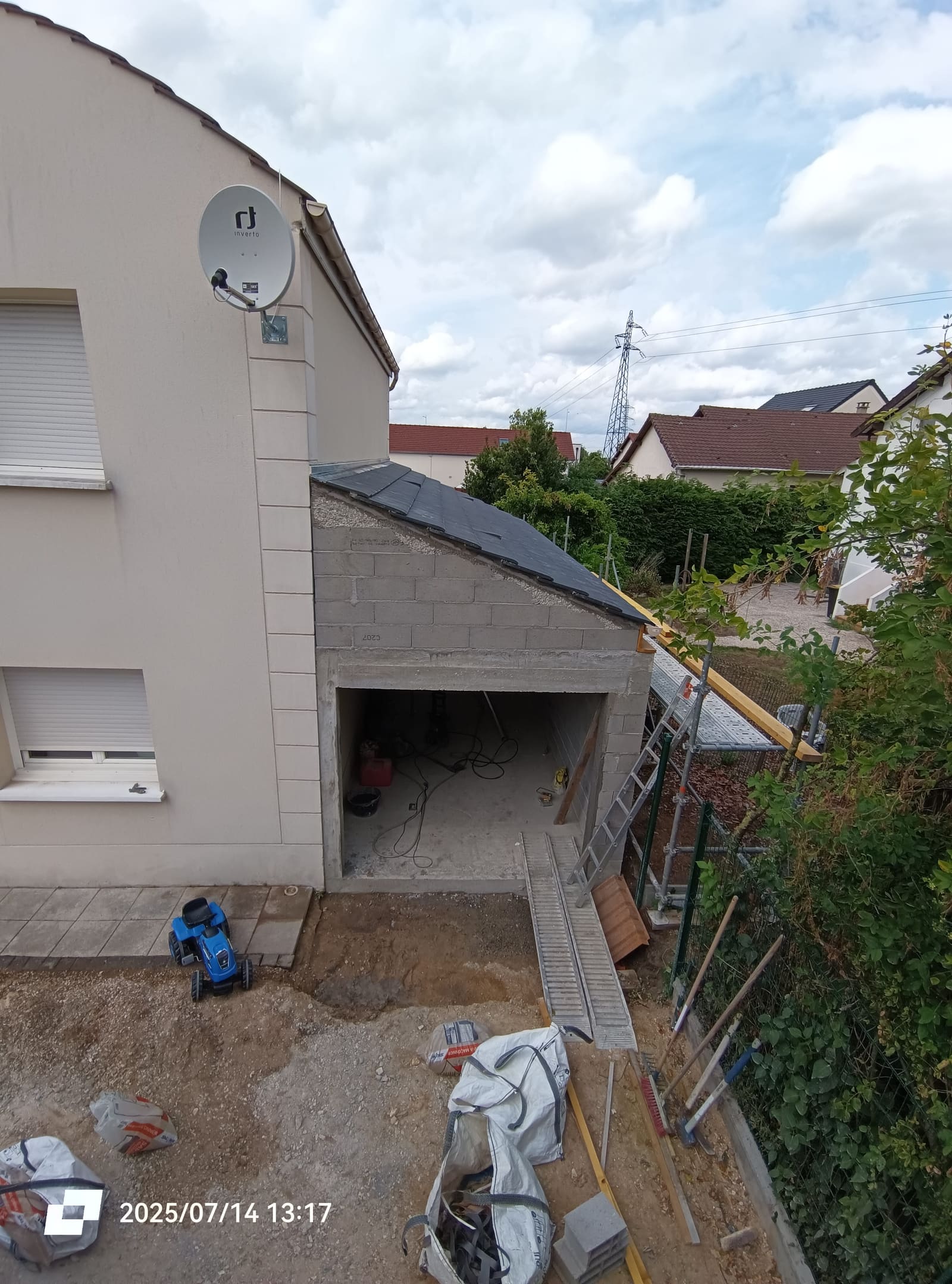 Garage terminé et couvert, accolé au pignon de la maison, vu depuis l’étage