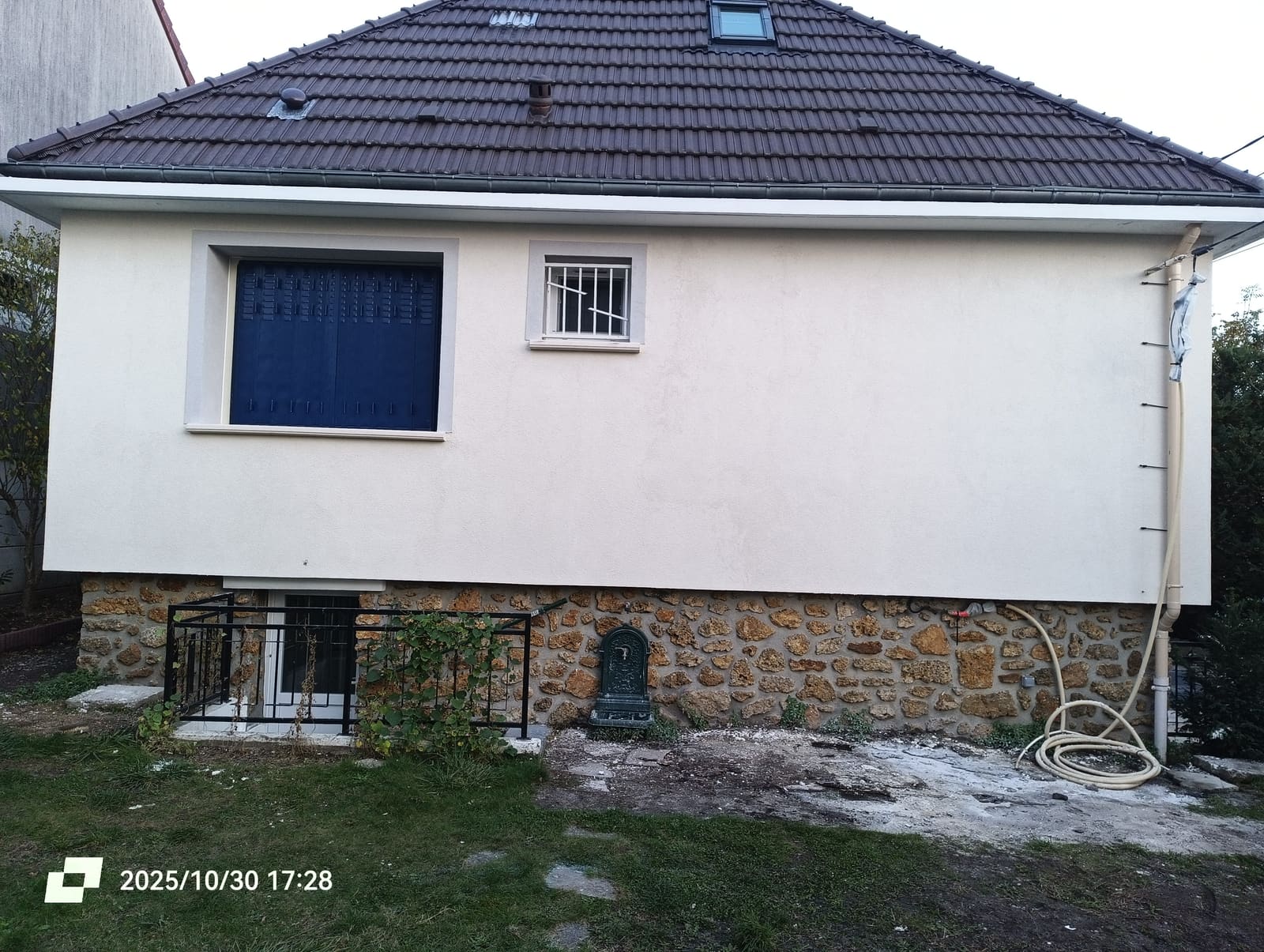 Façade isolée par l’extérieur avec soubassement en pierre laissé apparent